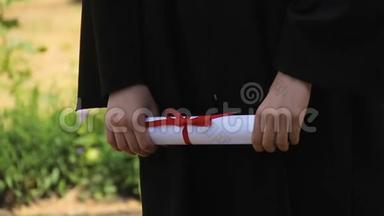 持有红丝带毕业证书的毕业生手，毕业典礼